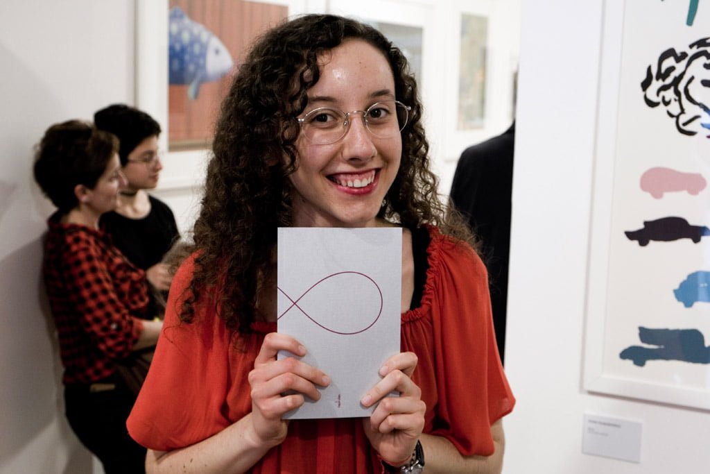 Giulia Colombo con in mano Otto, antologia del concorso di poesia di Tapirulan