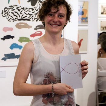 Serena Lampugnani con in mano Otto, antologia del concorso di poesia di Tapirulan