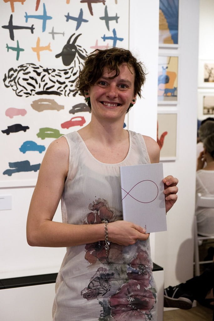 Serena Lampugnani con in mano Otto, antologia del concorso di poesia di Tapirulan